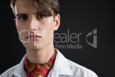 Androgynous man in muffler posing