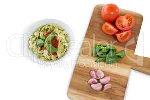 High angle view of vegetables on cutting board by pasta