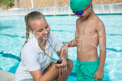 Female trainer showing stopwatch to boy