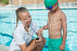 Female trainer showing stopwatch to boy