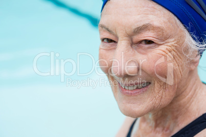 Smiling senior woman sitting at poolside