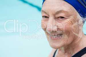 Smiling senior woman sitting at poolside