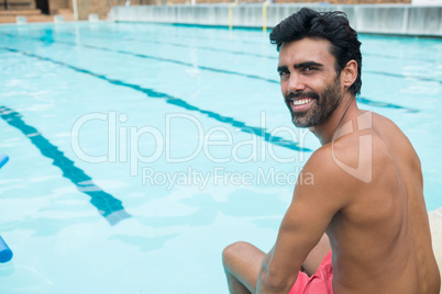 Portrait of fit man relaxing at poolside