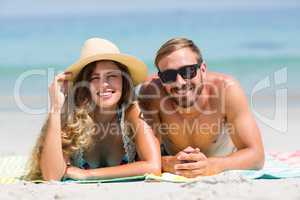 Happy couple lying at beach during sunny day