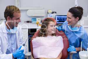 Smiling dentists interacting with young patient