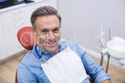 Smiling female patient sitting on dentist chair