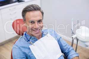 Smiling female patient sitting on dentist chair
