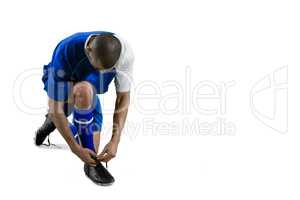 Football player tying his shoe lace