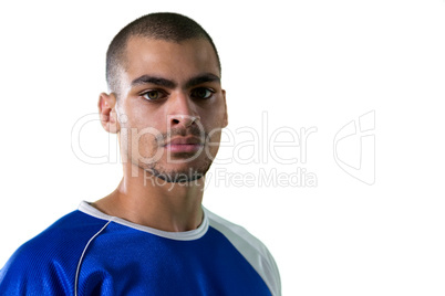 Portrait of football player standing against white background