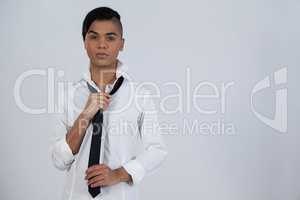 Transgender woman holding tie