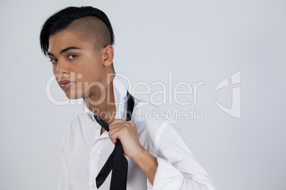Confident transgender female holding tie
