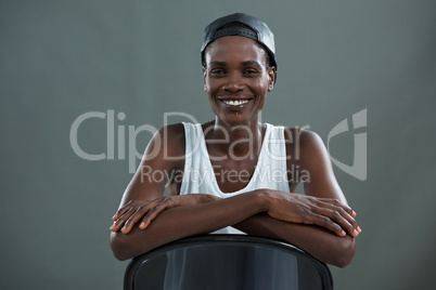 Androgynous man in cap smiling at camera