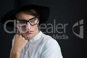 Androgynous man posing with hand on his cheek