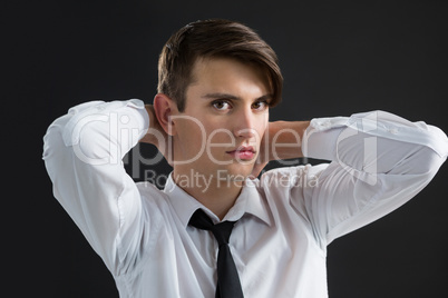 Androgynous man with hands on his neck