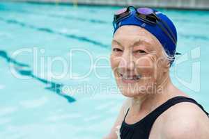 Smiling senior woman sitting at poolside