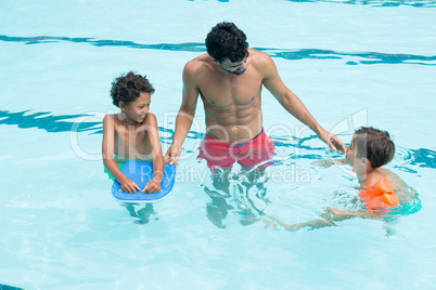 Father interacting with kids in the pool