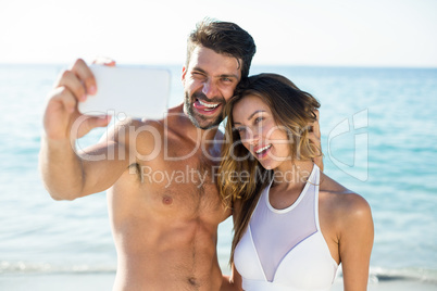 Young couple taking selfie at beach