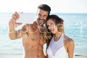Young couple taking selfie at beach