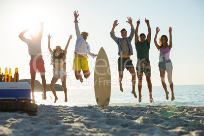 Happy friends jumping on shore at beach