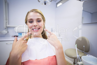 Smiling female patient sitting on dentists chair