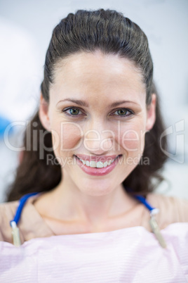Smiling female patient sitting on dentist chair
