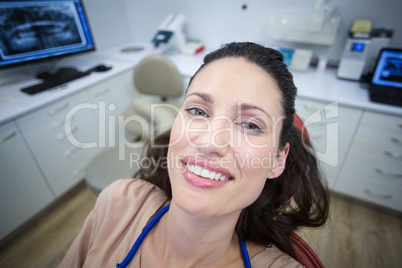 Smiling female patient sitting on dentist chair