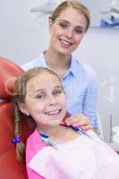 Smiling mother and daughter at dental clinic