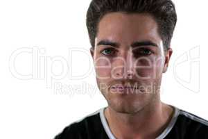 Portrait of football player standing against white background