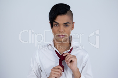 Portrait of transgender woman tying necktie