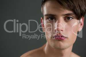 Shirtless androgynous man looking at camera