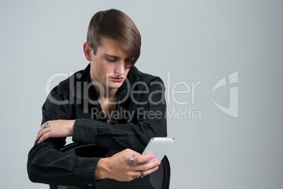 Androgynous man using mobile phone
