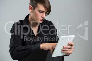 Androgynous man using digital tablet