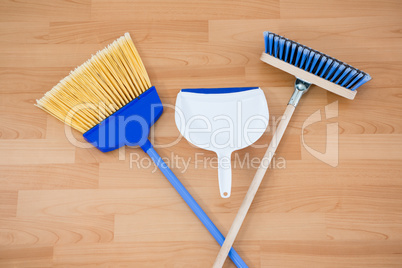 Overhead view of brooms with dustpan on floor