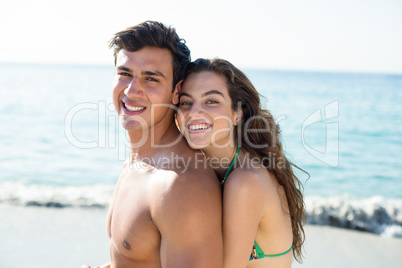 Young couple embracing while standing at beach