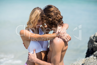 Couple embracing against sea