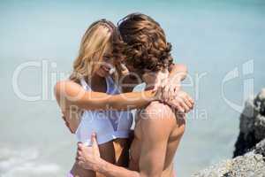 Couple embracing against sea