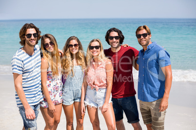 Young friends in sunglasses at beach on sunny day