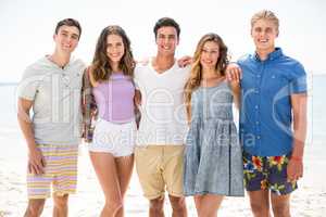 Smiling friends standing at beach