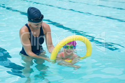 Female instructor training young girl in pool