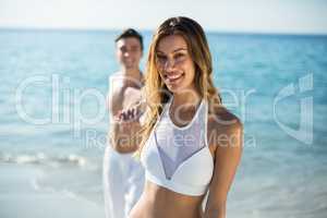 Woman holding boyfriend hand on shore at beach