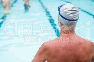 Senior man sitting at poolside