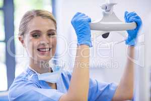 Portrait of female nurse adjusting dental light
