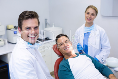 Portrait of smiling dentists and male patient
