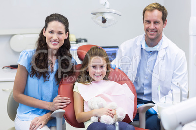 Portrait of dentist with young patient and her mother