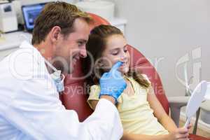 Smiling young patient looking in the mirror in dental clinic