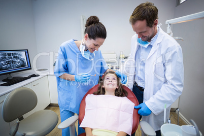 Smiling dentists interacting with young patient