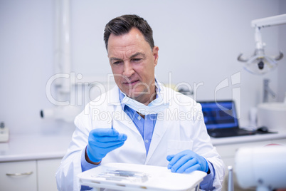 Dentist checking tools in dental clinic