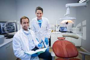 Portrait of smiling dentists holding medical report