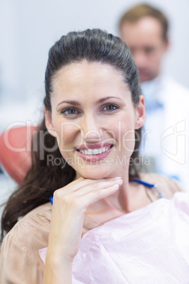 Smiling female patient sitting on dentist chair