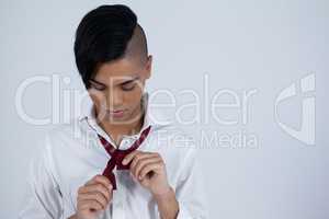 Transgender woman tying necktie
